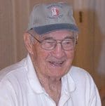 An older man wearing glasses and a hat.