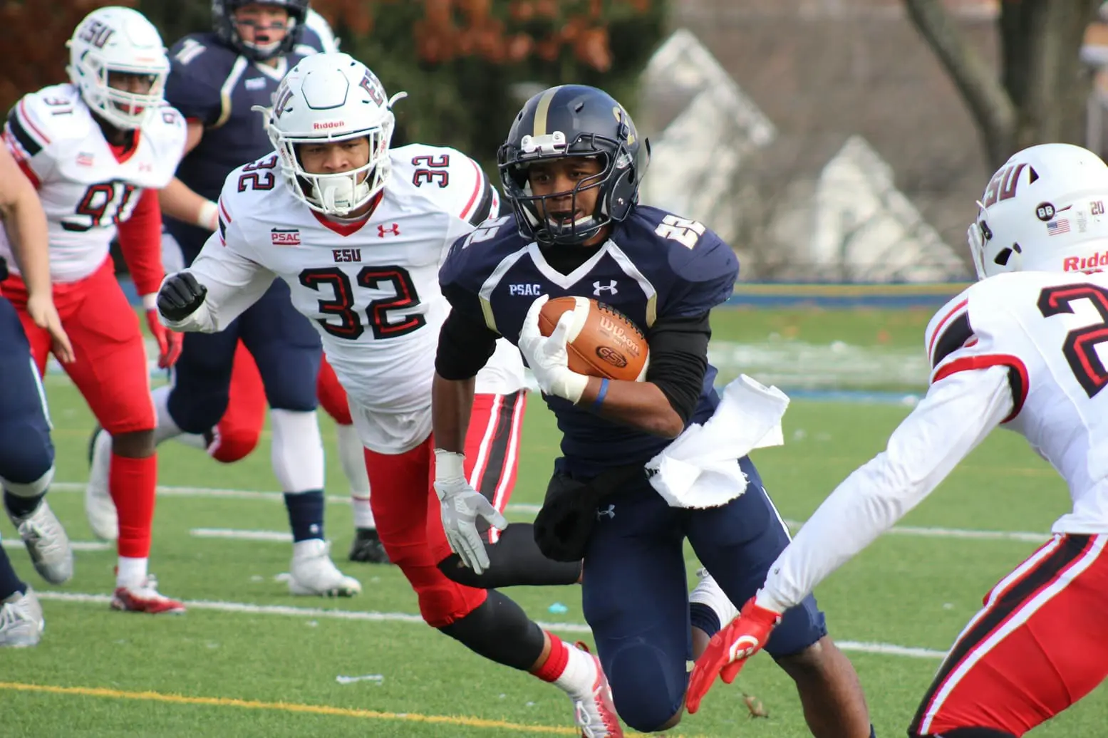 A football player running with the ball while another player is in position to catch it.