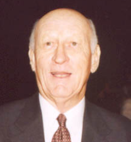 A man in suit and tie smiling for the camera.