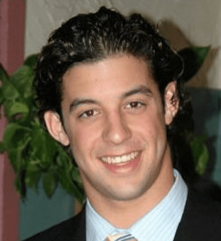 A man with curly hair and a suit.