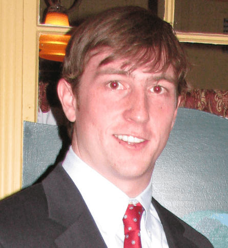 A man in suit and tie smiling for the camera.