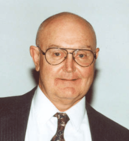 A man with glasses and bald head wearing a suit.