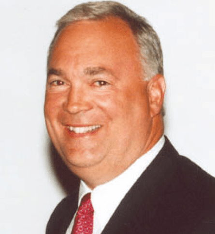 A man in suit and tie smiling for the camera.