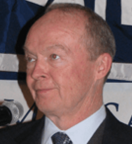 A man in suit and tie next to microphone.