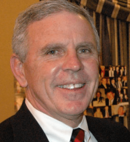 A man in suit and tie smiling for the camera.