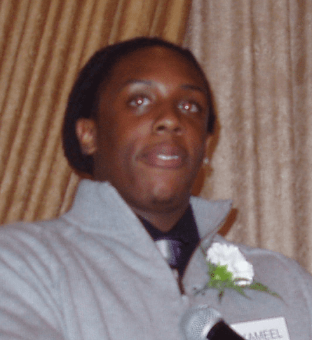 A man in a gray jacket and tie holding flowers.