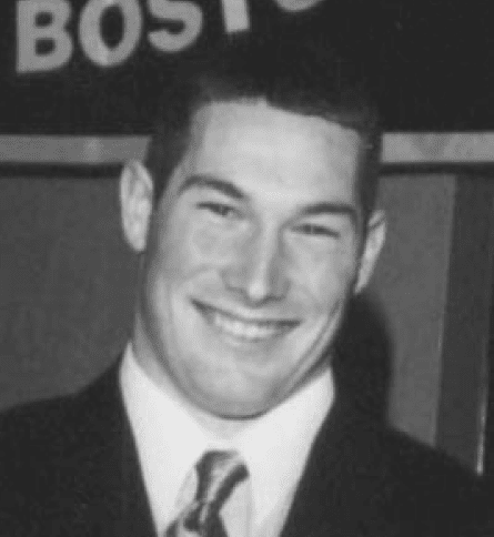 A man in suit and tie smiling for the camera.