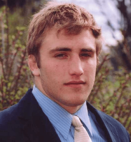 A man in a suit and tie standing outside.