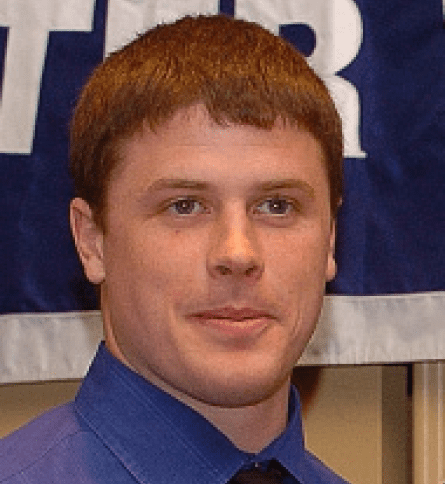 A man with red hair and blue shirt.