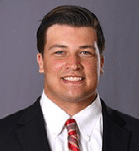 A man in suit and tie smiling for the camera.