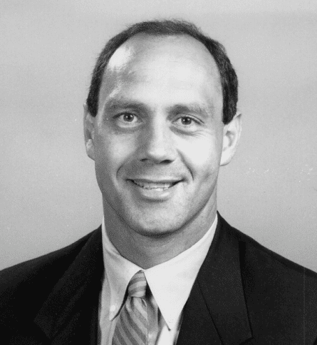 A man in suit and tie smiling for the camera.