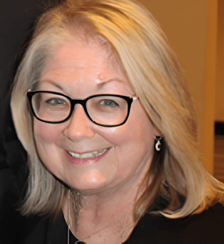 A woman with glasses smiling for the camera.