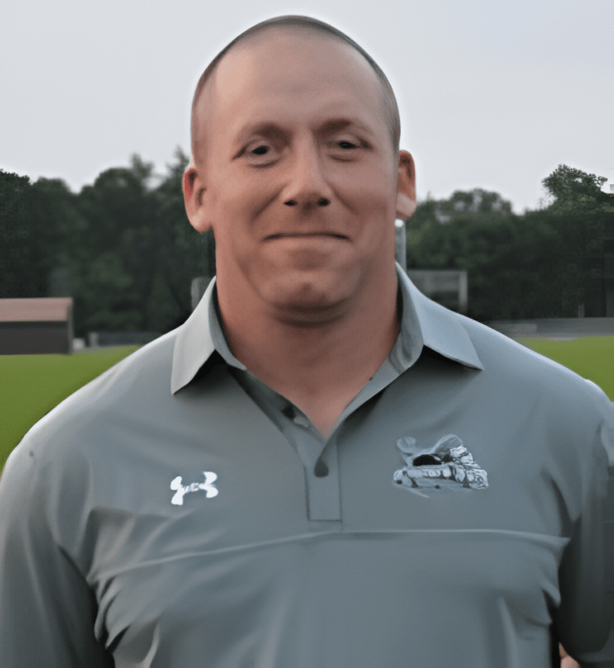 A man in grey shirt and white under armour logo.