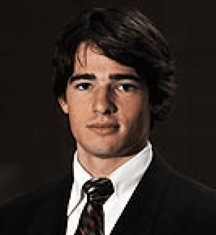 A man in suit and tie with long hair.