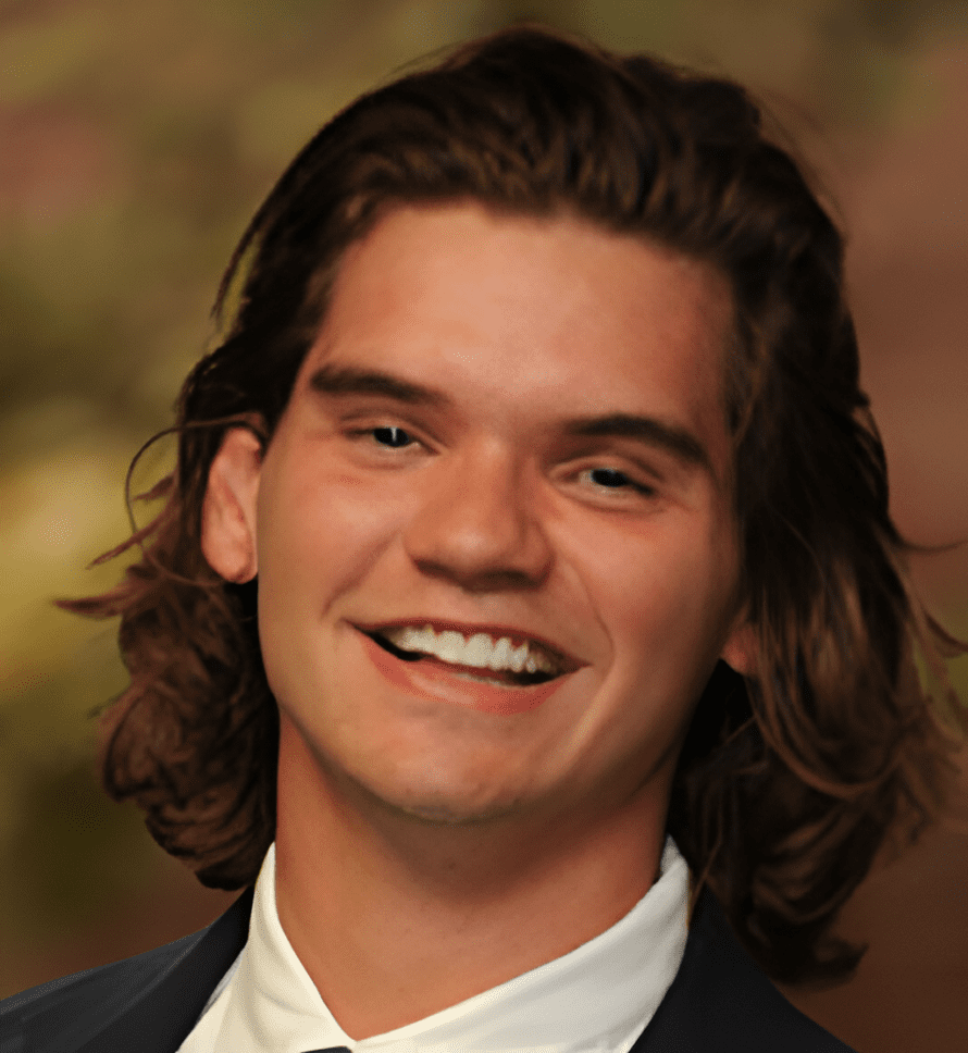 A man with long hair and white teeth smiling.