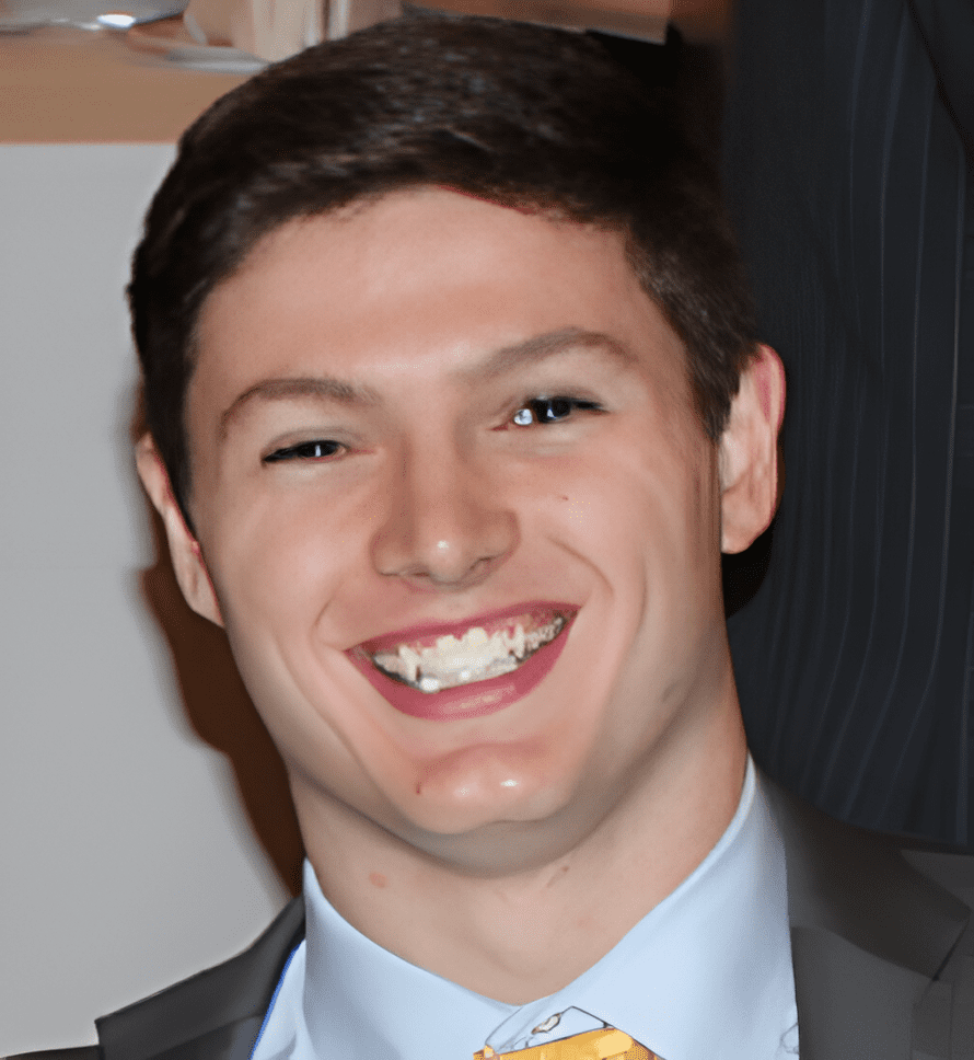 A man in suit and tie smiling for the camera.