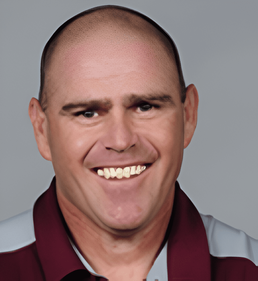 A man with bald head and wearing maroon shirt.