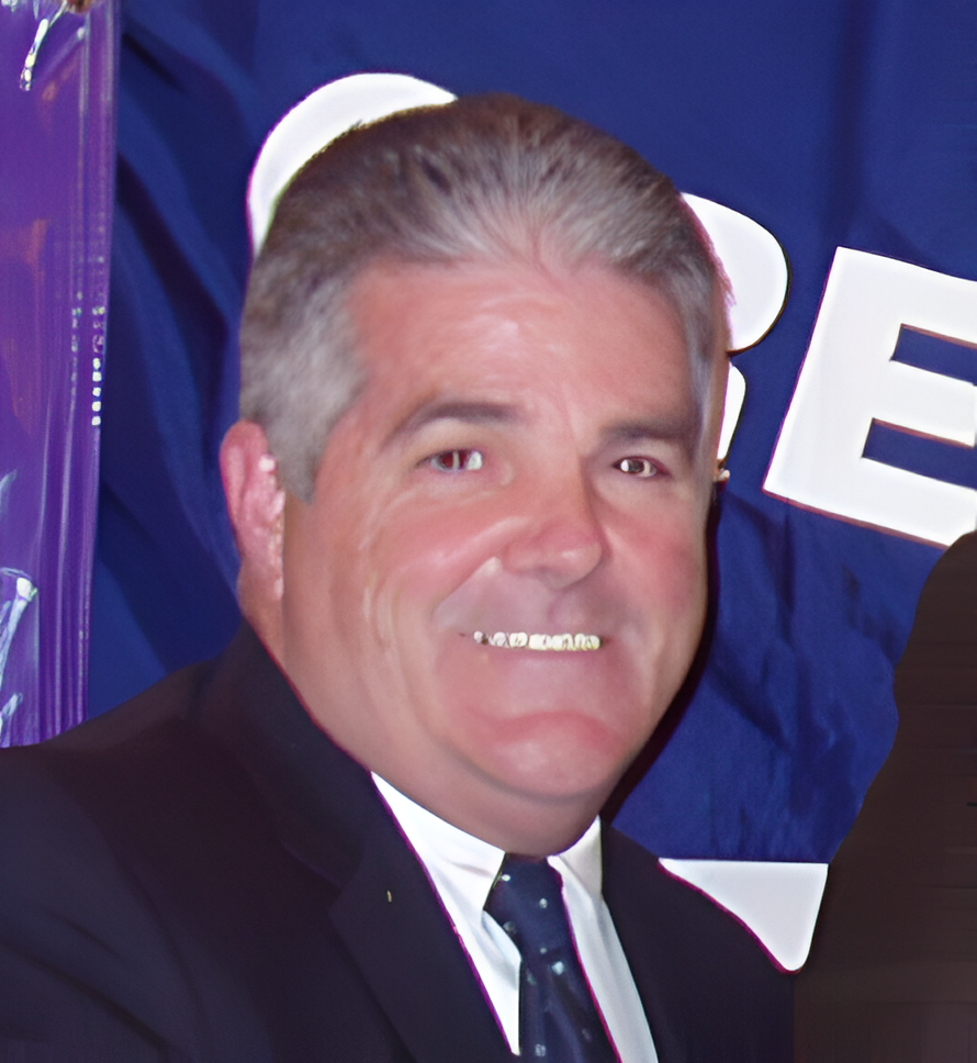 A man in suit and tie smiling for the camera.