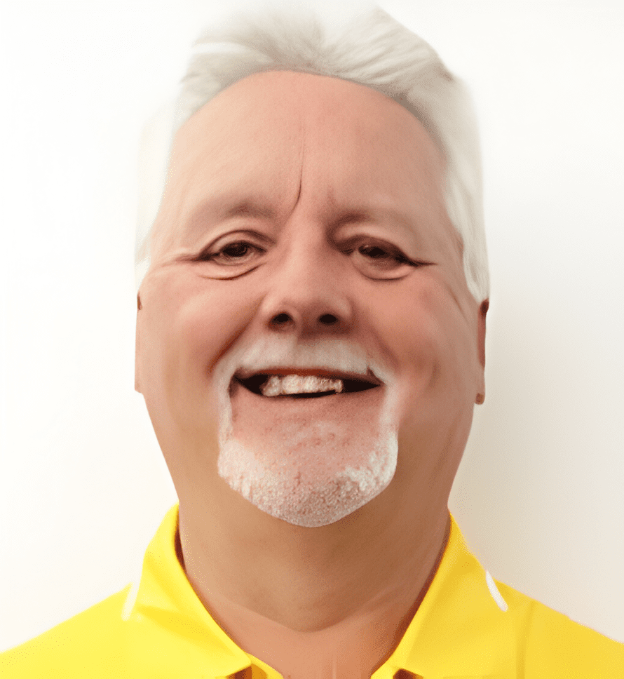 A man with white hair and a yellow shirt.