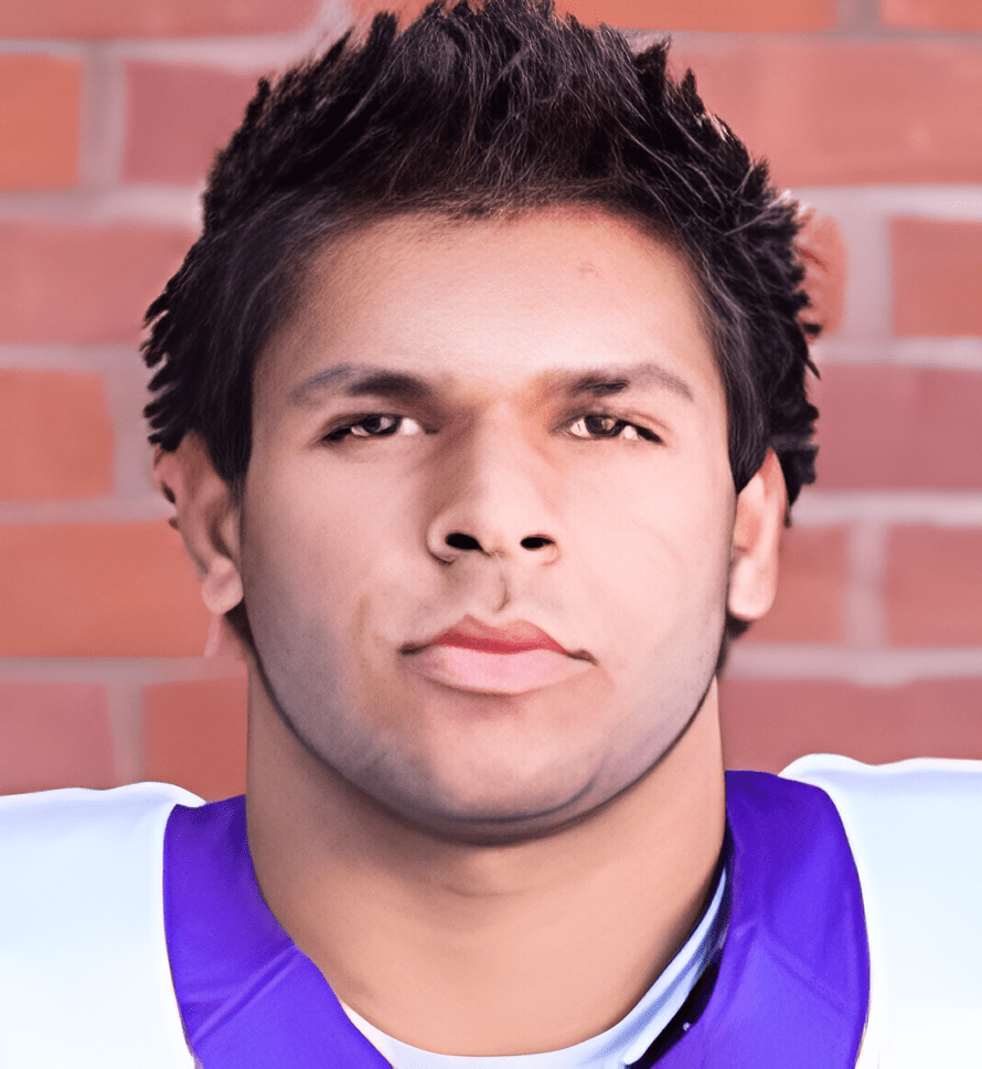 A close up of a football player with a brick wall in the background