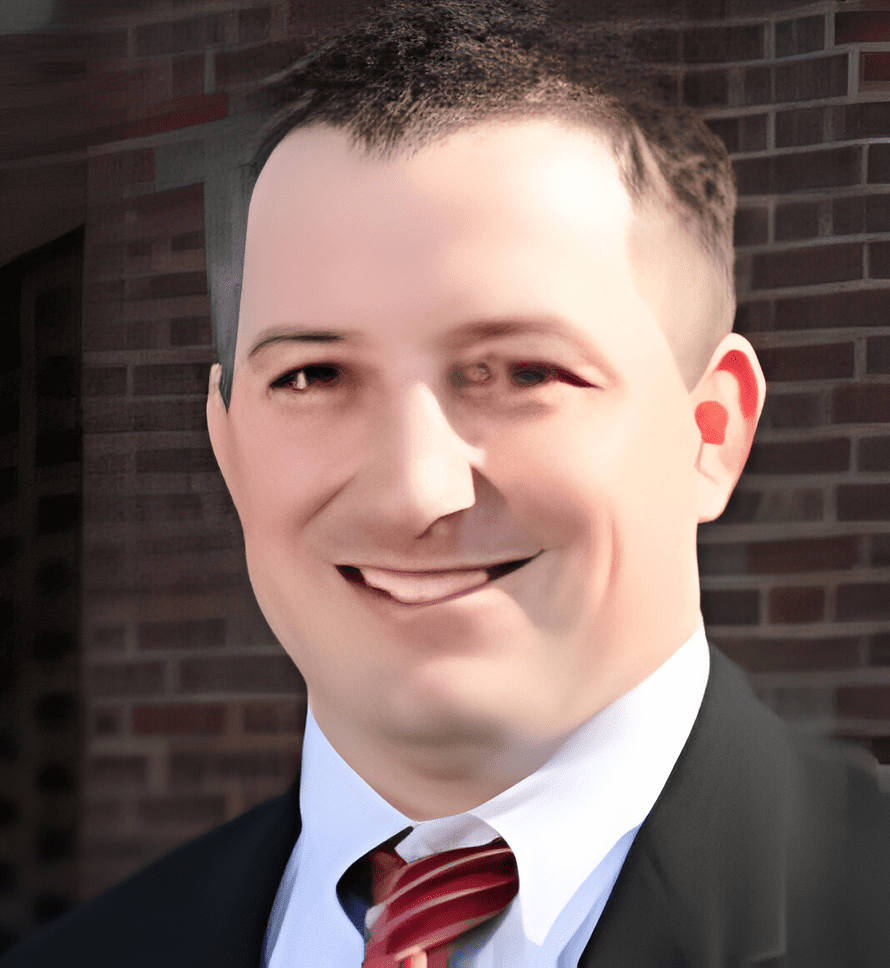 A man in suit and tie smiling for the camera.