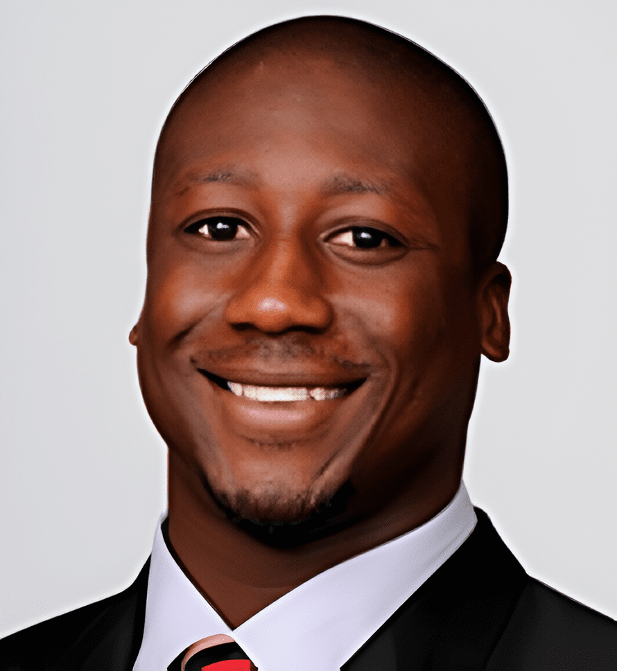 A man in suit and tie smiling for the camera.