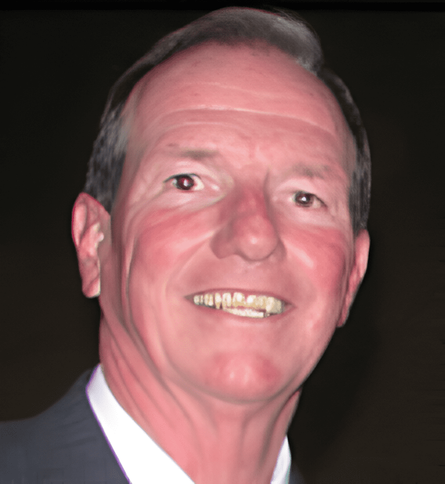 A man with a suit and tie smiling for the camera.