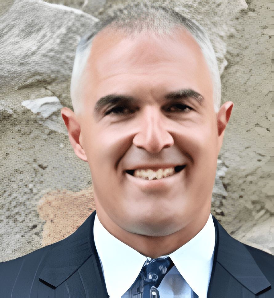 A man in suit and tie smiling for the camera.