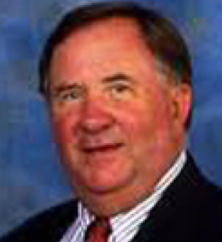 A man in suit and tie smiling for the camera.