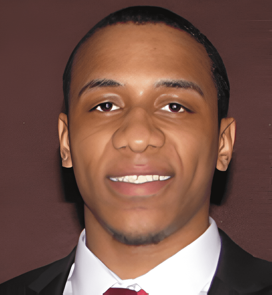 A man in a suit and tie smiling for the camera.