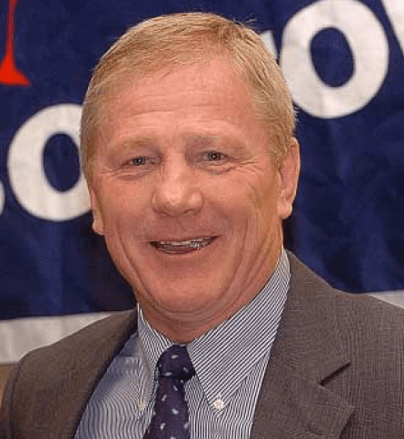 A man in suit and tie smiling for the camera.