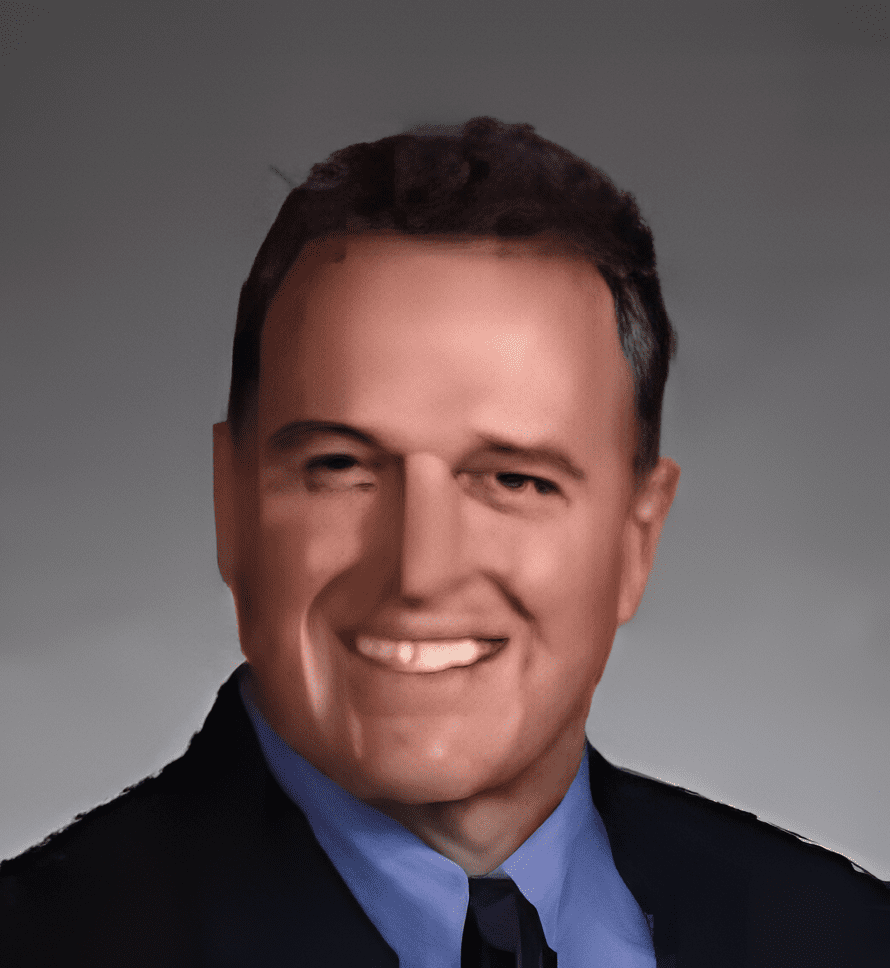 A man in a suit and tie smiling for the camera.