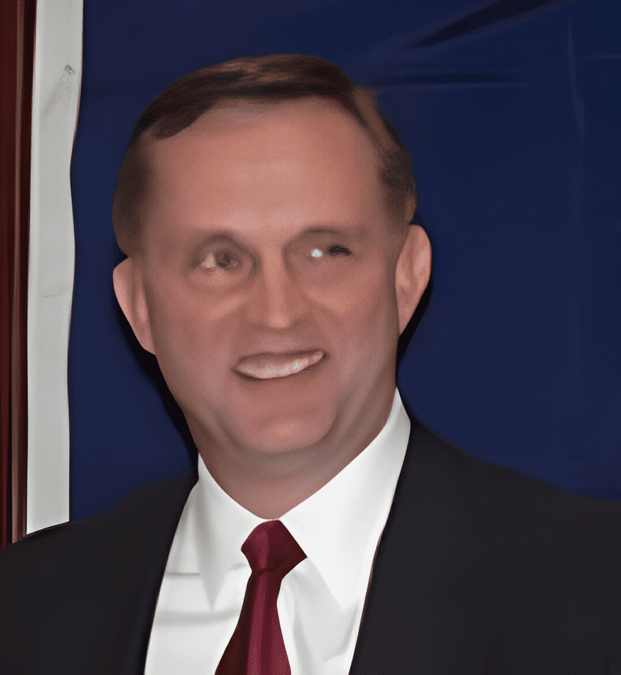 A man in suit and tie smiling for the camera.