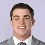 A man in suit and tie smiling for the camera.