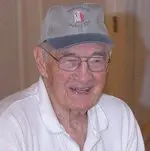 An older man wearing glasses and a hat.