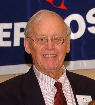 A man in a suit and tie smiling for the camera.