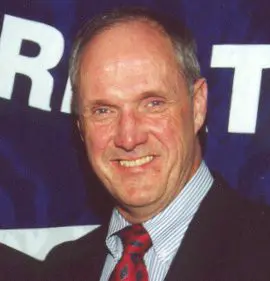 A man in suit and tie smiling for the camera.