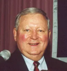 A man in suit and tie smiling for the camera.