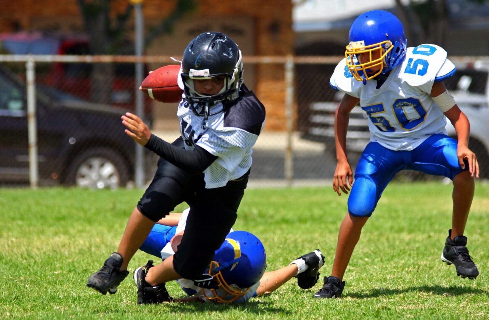 A group of young people playing football on the field.